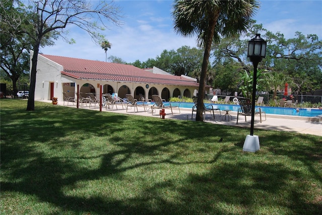 view of community featuring a pool, a patio area, and a lawn