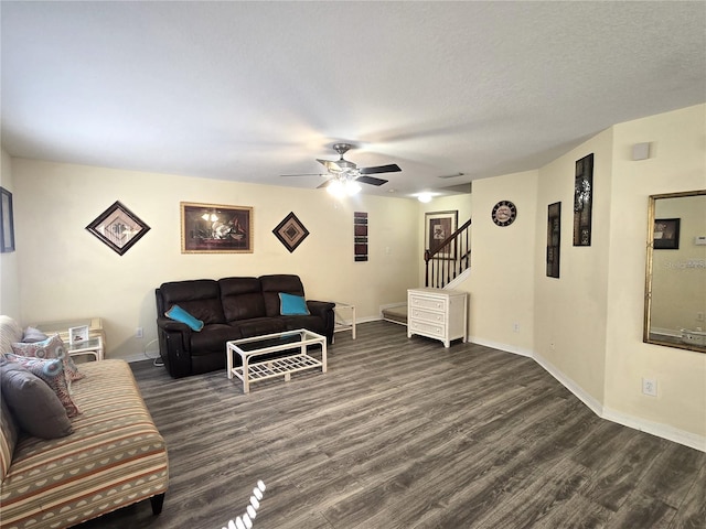 living room featuring a textured ceiling, ceiling fan, and dark wood-type flooring