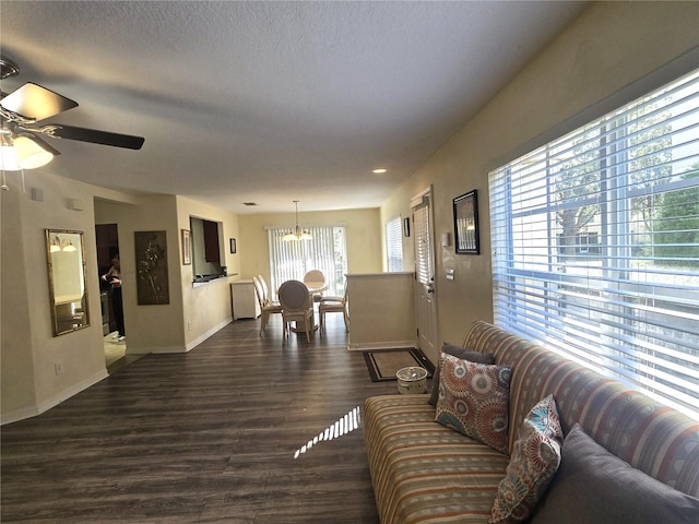 living room with plenty of natural light, dark hardwood / wood-style floors, a textured ceiling, and ceiling fan