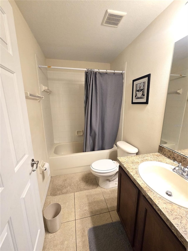 full bathroom featuring tile patterned flooring, a textured ceiling, toilet, shower / tub combo with curtain, and vanity