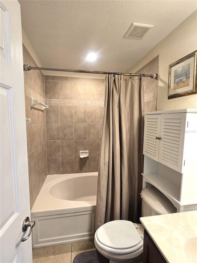 full bathroom featuring a textured ceiling, vanity, toilet, and shower / bath combo with shower curtain