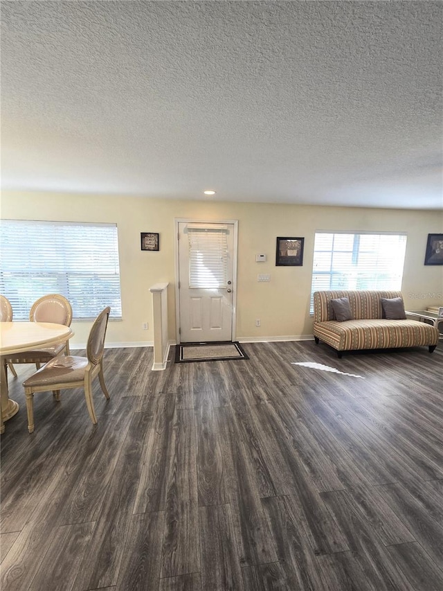 entrance foyer with dark hardwood / wood-style flooring and a textured ceiling