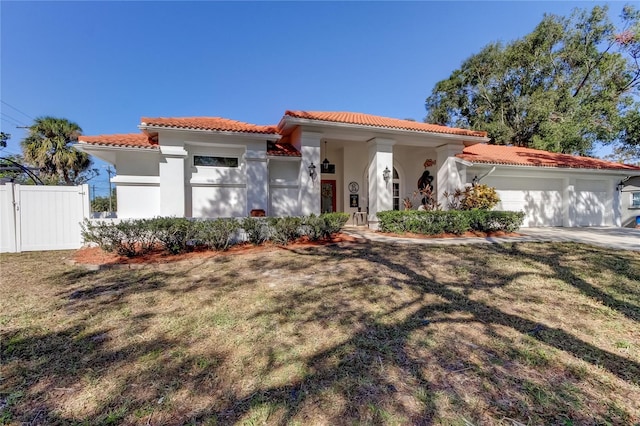 mediterranean / spanish-style home featuring a front yard and a garage