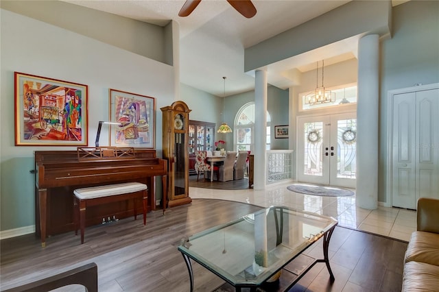 interior space featuring french doors, ceiling fan with notable chandelier, and hardwood / wood-style flooring