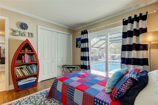 bedroom featuring access to exterior, crown molding, wood-type flooring, a textured ceiling, and a closet