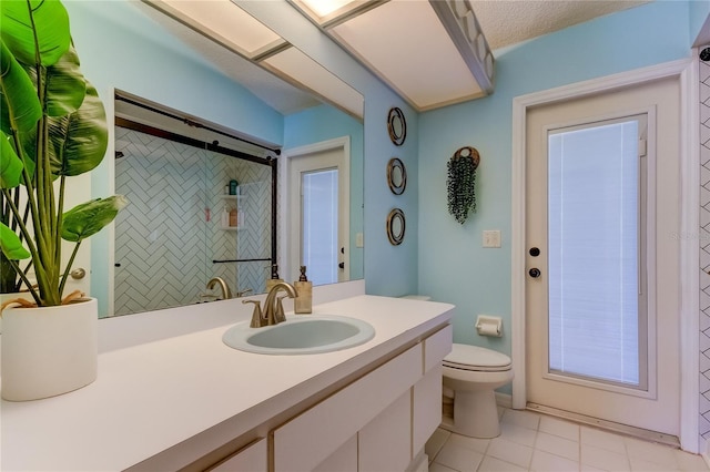 bathroom featuring a tile shower, tile patterned flooring, a textured ceiling, toilet, and vanity