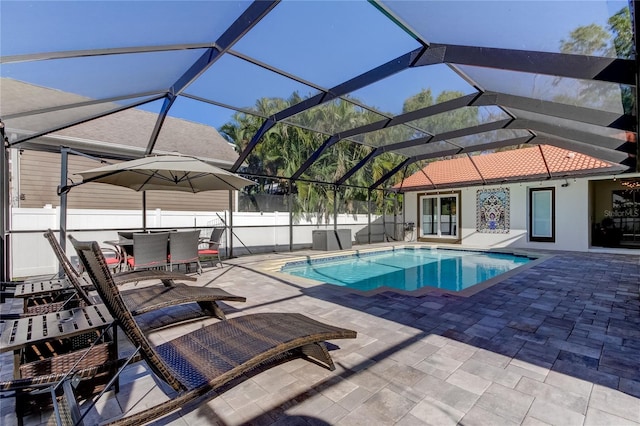 view of pool featuring glass enclosure and a patio area