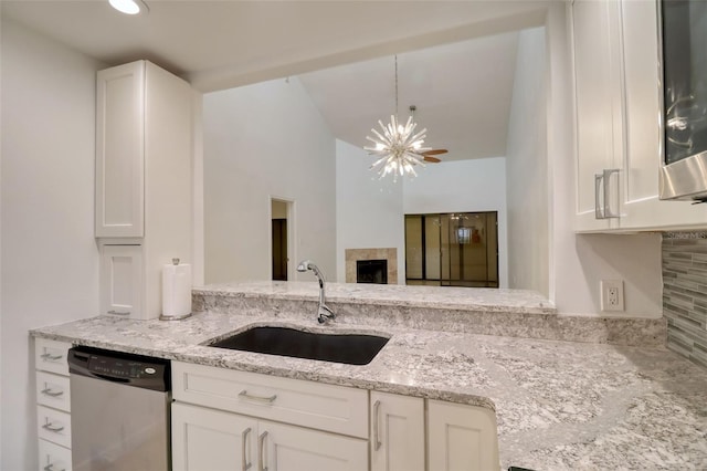 kitchen with stainless steel appliances, white cabinetry, a notable chandelier, and sink