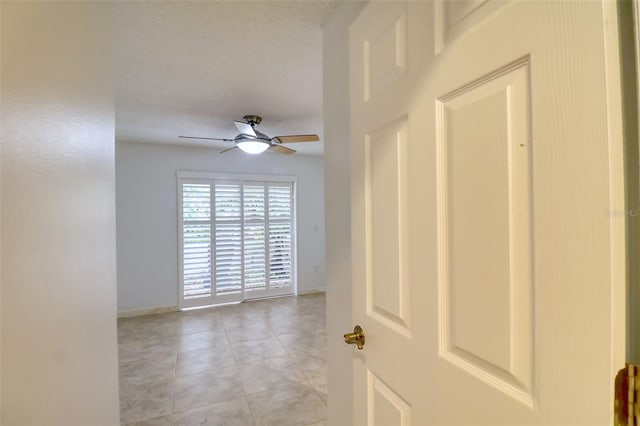 unfurnished room featuring ceiling fan and light tile patterned flooring