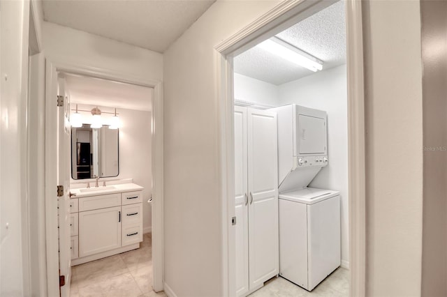 washroom featuring stacked washer / dryer and sink