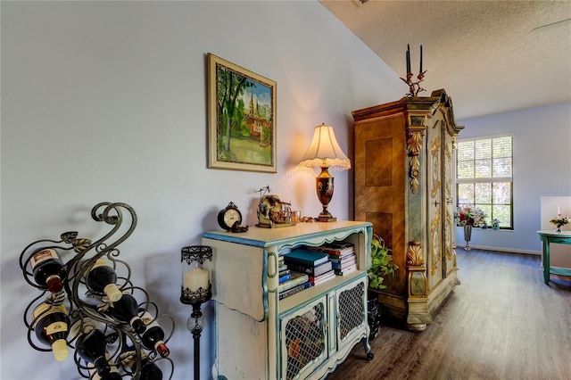 hallway with dark wood-type flooring and a textured ceiling