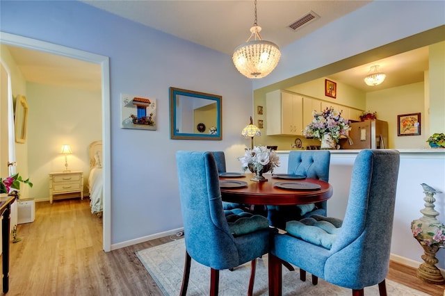 dining room featuring a notable chandelier and light wood-type flooring