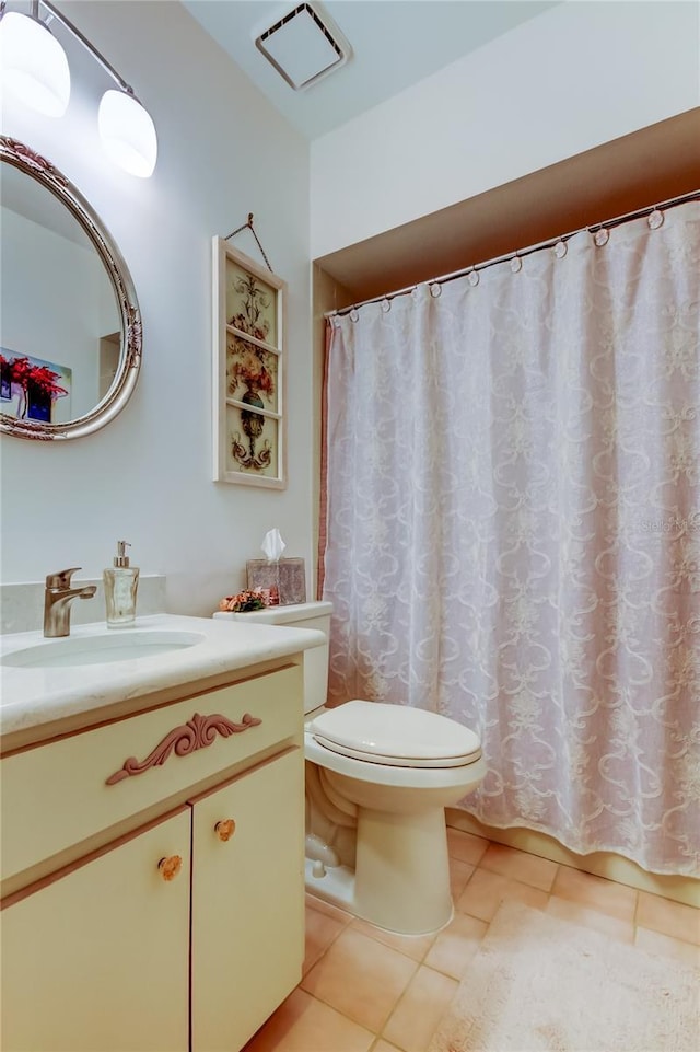 bathroom featuring tile patterned flooring, vanity, and toilet