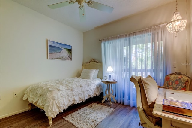 bedroom with hardwood / wood-style floors and ceiling fan with notable chandelier