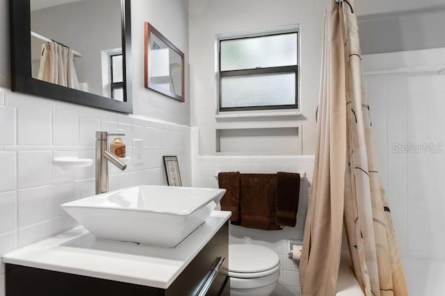 full bathroom featuring vanity, toilet, tile walls, and shower / bath combo with shower curtain