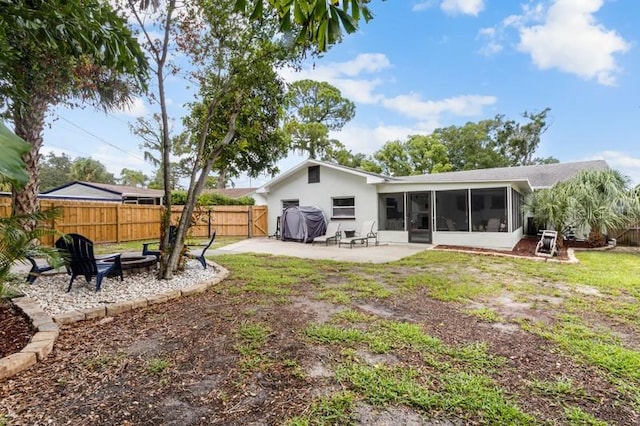 rear view of house featuring a yard, a patio area, and a sunroom