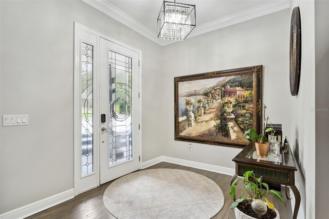 foyer entrance with a notable chandelier, dark hardwood / wood-style floors, and ornamental molding