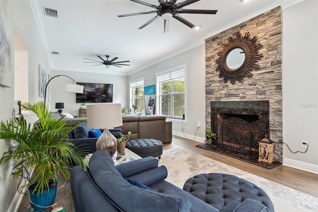 living room featuring a fireplace, ceiling fan, wood-type flooring, and crown molding