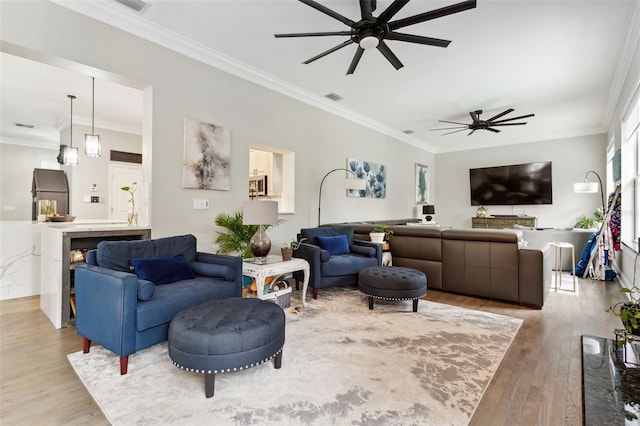 living room featuring hardwood / wood-style flooring, ceiling fan, and crown molding