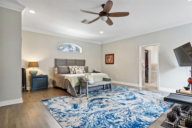 bedroom featuring ceiling fan, ensuite bathroom, wood-type flooring, and ornamental molding