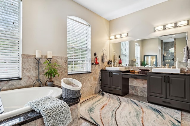 bathroom featuring vanity, tile walls, and tiled tub