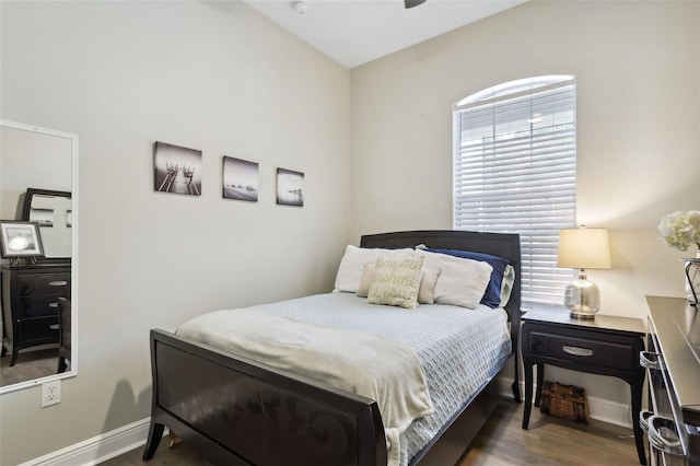 bedroom with multiple windows and dark wood-type flooring