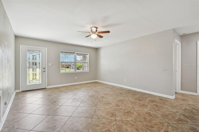 unfurnished room with light tile patterned floors and ceiling fan