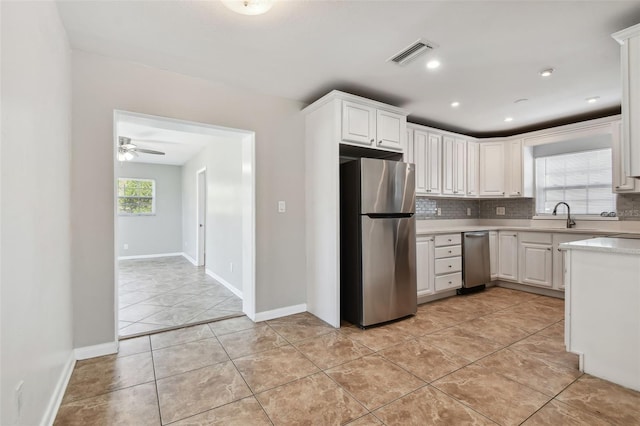 kitchen with stainless steel fridge, tasteful backsplash, ceiling fan, light tile patterned floors, and white cabinetry