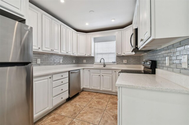 kitchen with backsplash, sink, white cabinets, and stainless steel appliances