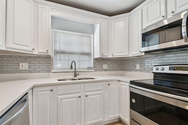 kitchen with white cabinets, backsplash, sink, and stainless steel appliances