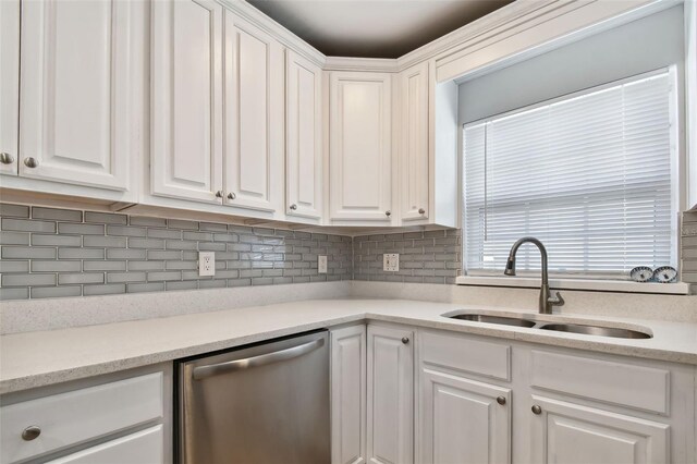 kitchen featuring stainless steel dishwasher, white cabinetry, sink, and tasteful backsplash