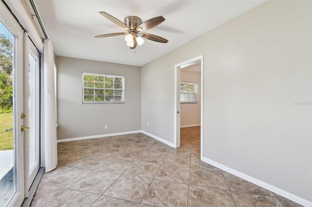 tiled empty room featuring ceiling fan