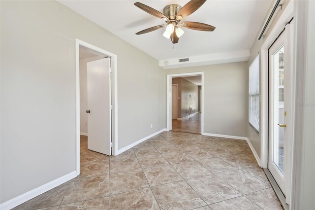 tiled spare room featuring ceiling fan and a healthy amount of sunlight