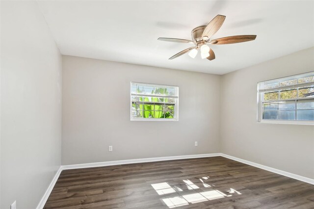 spare room featuring dark hardwood / wood-style floors, ceiling fan, and a healthy amount of sunlight