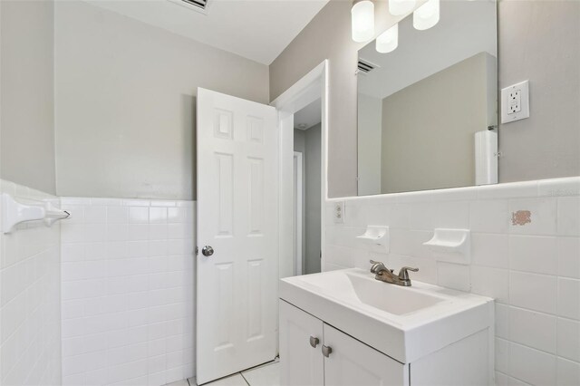 bathroom with tile patterned floors, vanity, and tile walls