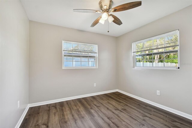 empty room featuring ceiling fan, dark hardwood / wood-style flooring, and a wealth of natural light