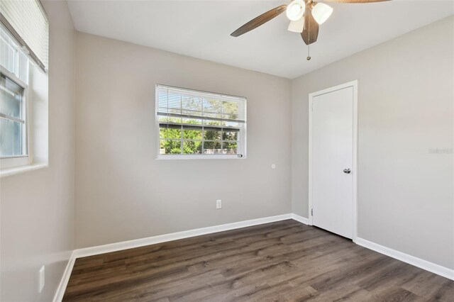 empty room with ceiling fan and dark hardwood / wood-style floors