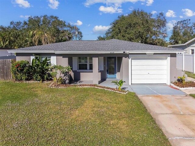 single story home with a garage and a front lawn