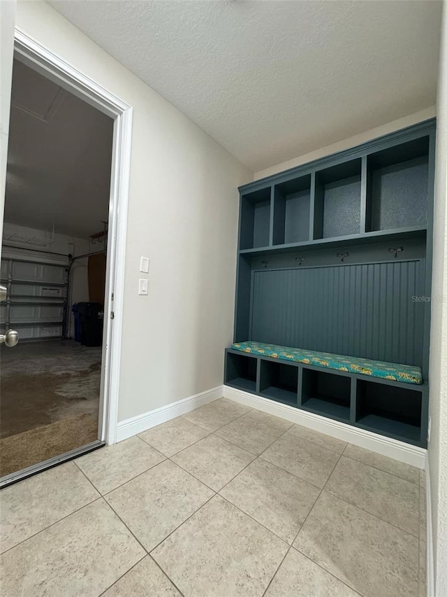 mudroom with tile patterned flooring and a textured ceiling