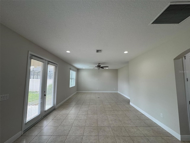 tiled empty room featuring ceiling fan, french doors, and a textured ceiling