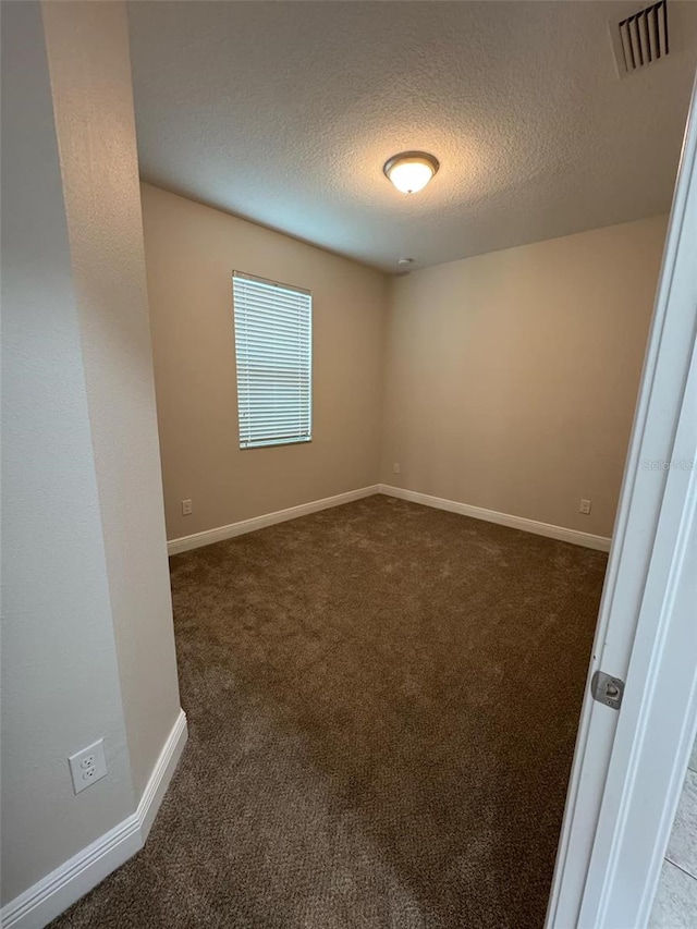 carpeted spare room featuring a textured ceiling