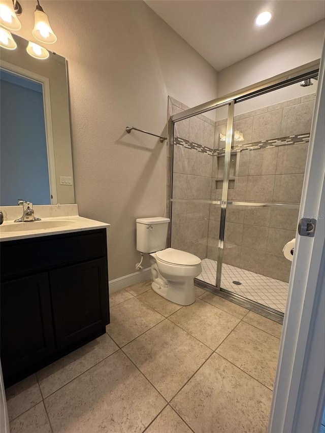 bathroom with tile patterned flooring, vanity, toilet, and an enclosed shower