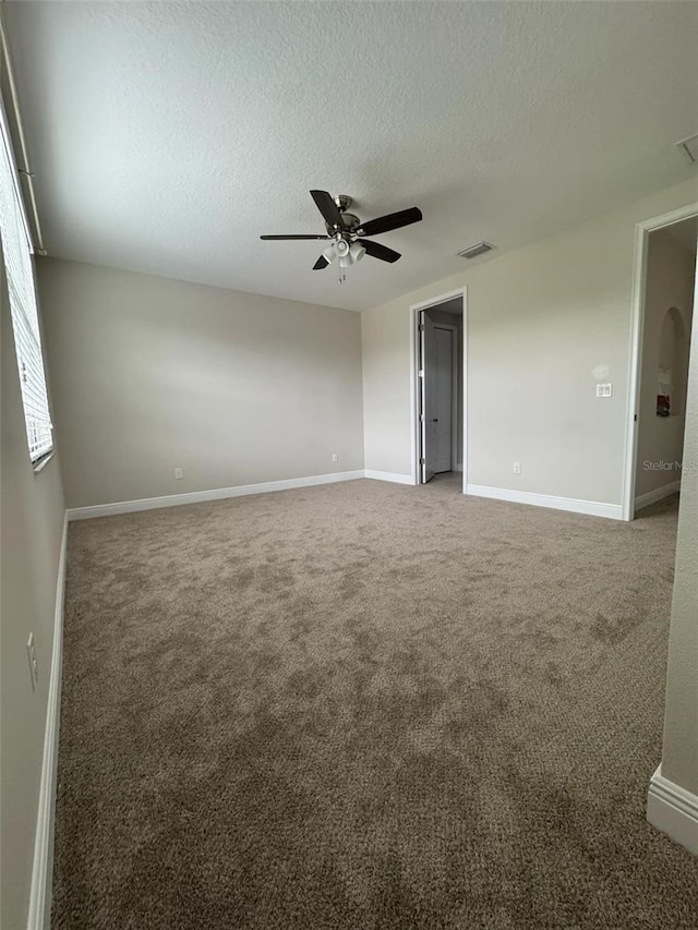 carpeted empty room featuring ceiling fan and a textured ceiling