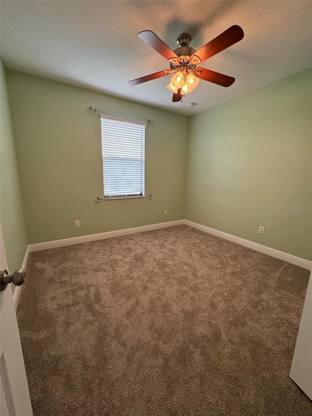 carpeted empty room featuring ceiling fan and a textured ceiling