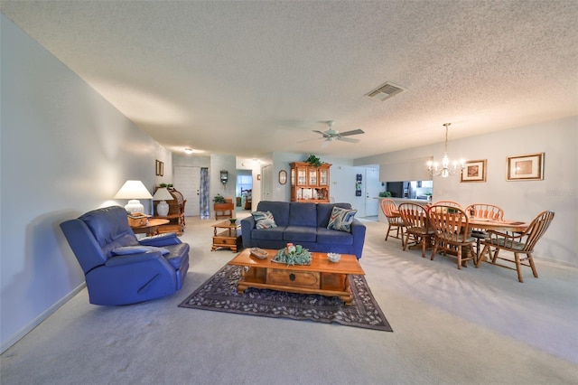 living room featuring ceiling fan with notable chandelier, a textured ceiling, and carpet floors