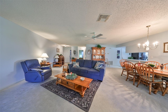 living room with carpet flooring, ceiling fan with notable chandelier, and a textured ceiling