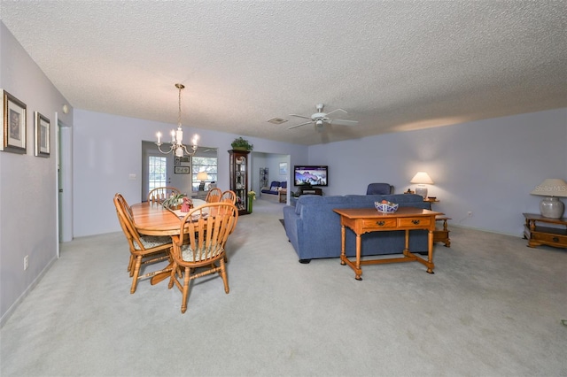 dining room with light carpet, ceiling fan with notable chandelier, and a textured ceiling