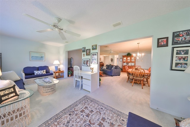 living room featuring ceiling fan with notable chandelier, light colored carpet, and a textured ceiling