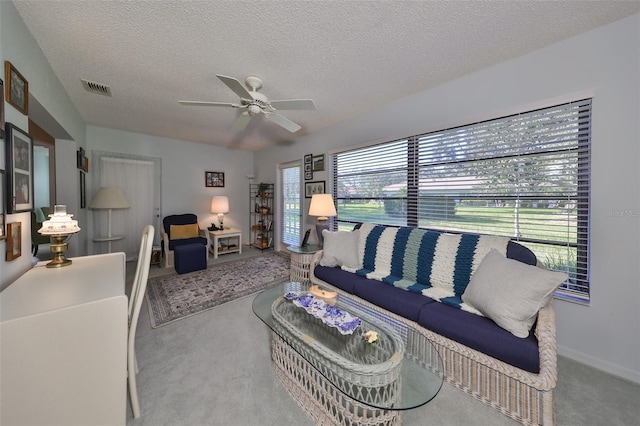 living room with carpet flooring, a textured ceiling, and ceiling fan