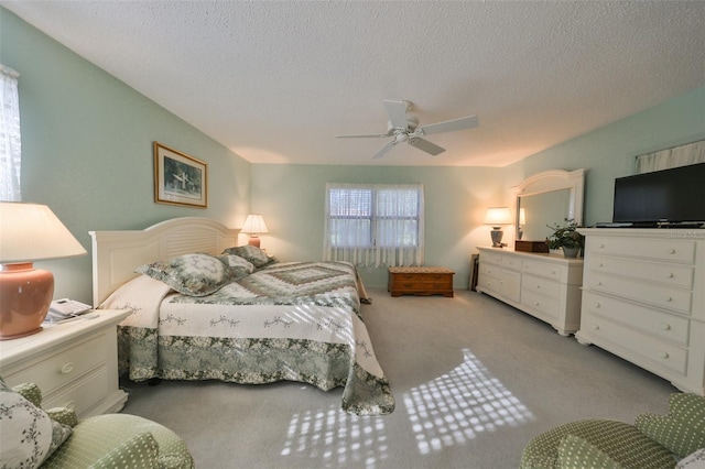 bedroom featuring ceiling fan, light colored carpet, and a textured ceiling